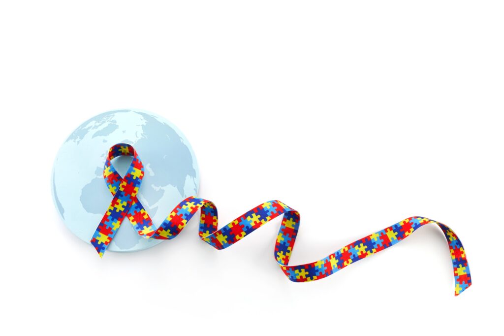 World Autism awareness and pride day or month with Puzzle pattern ribbon on white background
