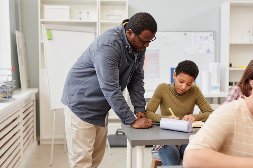 Black Teacher Helping Girl in Class