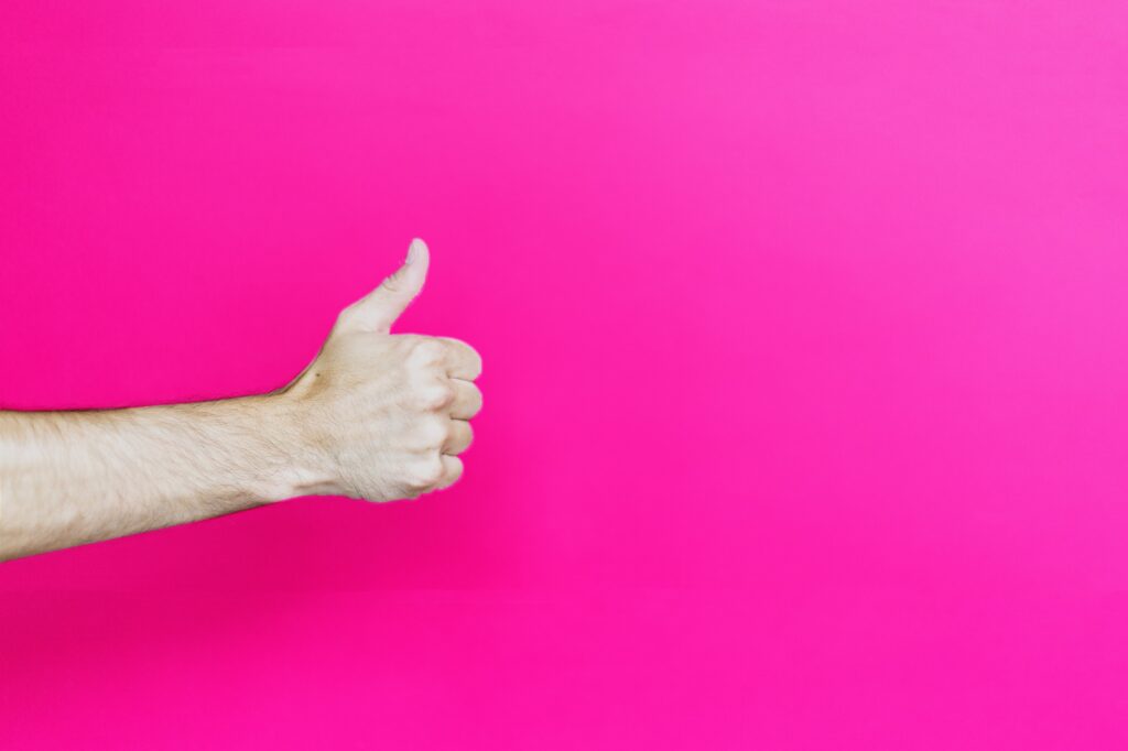 Hand doing “ok” sign on purple background