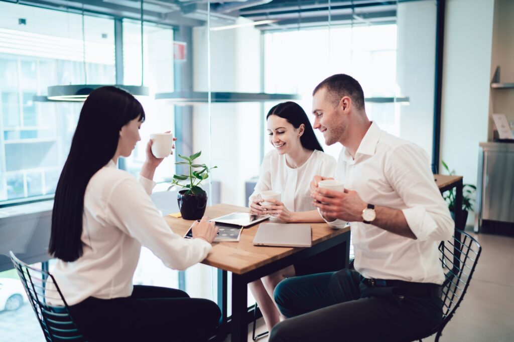 Happy office workers talking in cafe