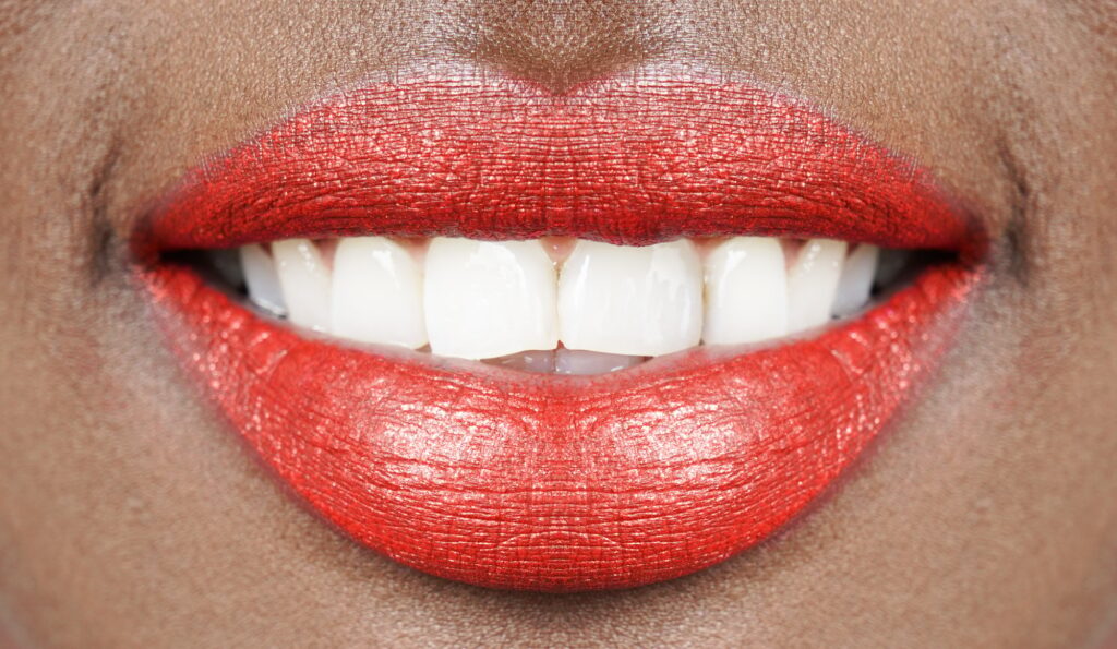 Mouth of African woman with red lips and shining white teeth