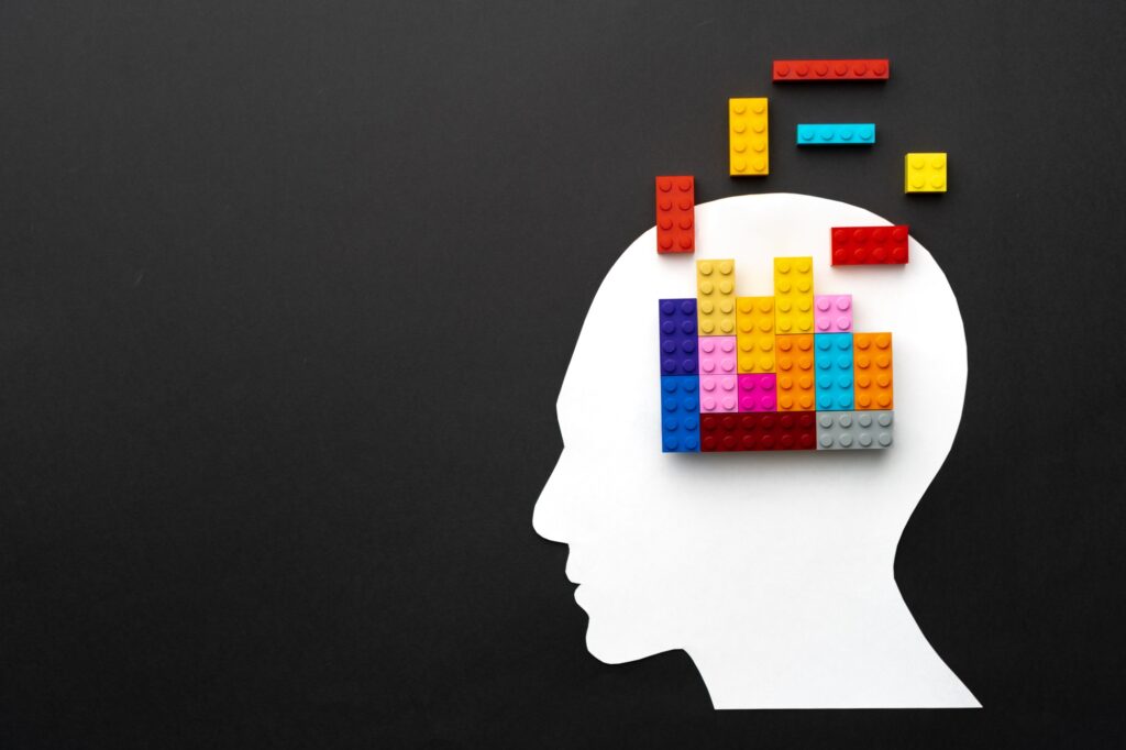 Papercut silhouette of human head with colorful constructor pieces