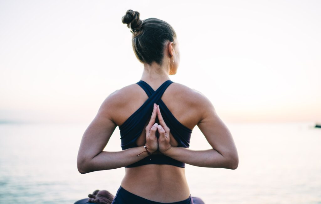Relaxed fit girl in sportswear keeping body shape in tonus enjoying hatha style of workout