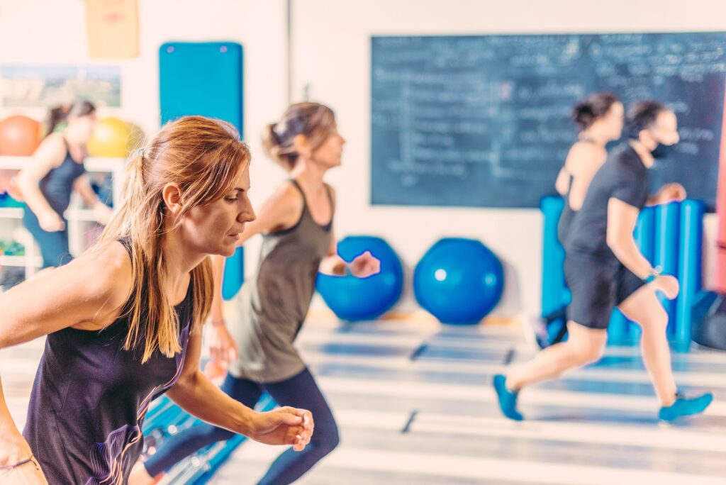 Side view of women doing aerobic exercises in health club