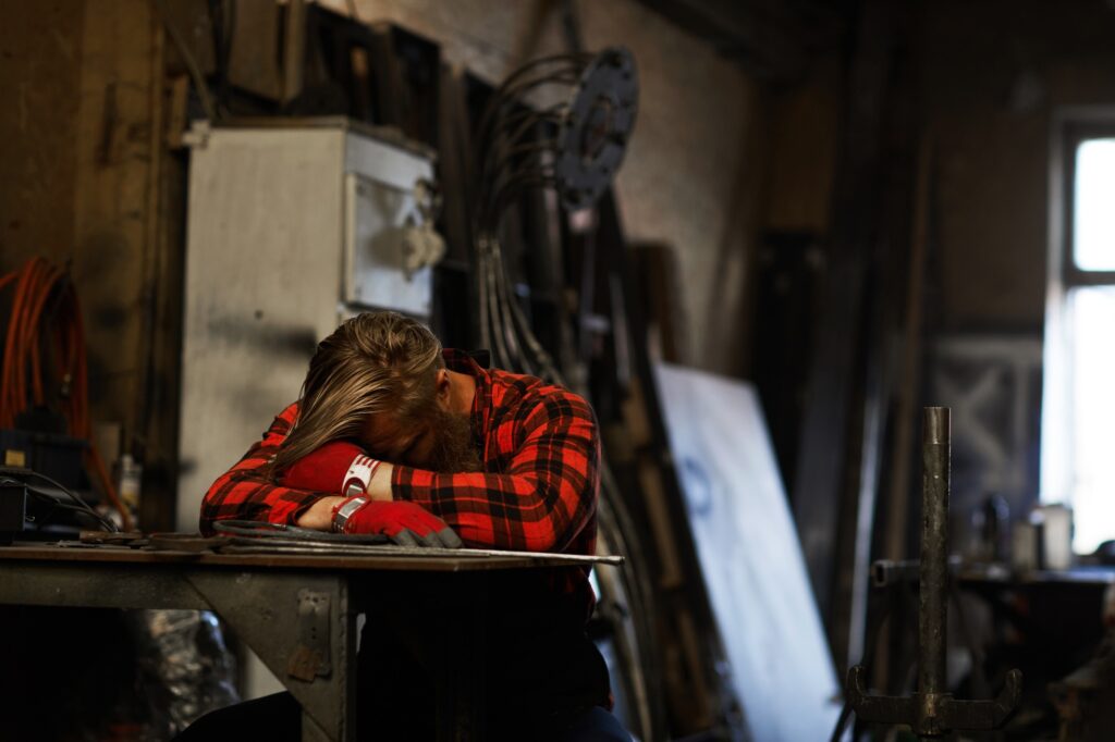 Tired blacksmith sleeping in workshop