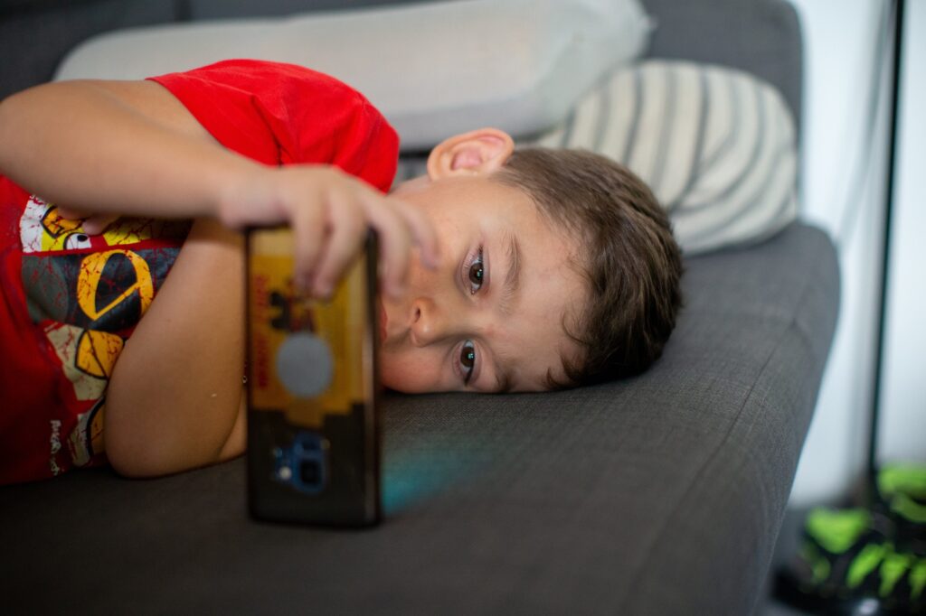 Closeup on an Autistic kid using a mobile phone to watch videos