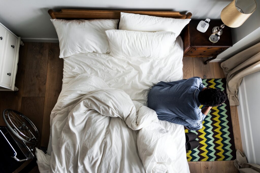 Lonely man sitting alone on the bed