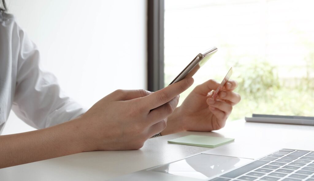 Online payment,woman's hands holding smartphone and using credit card for online shopping.