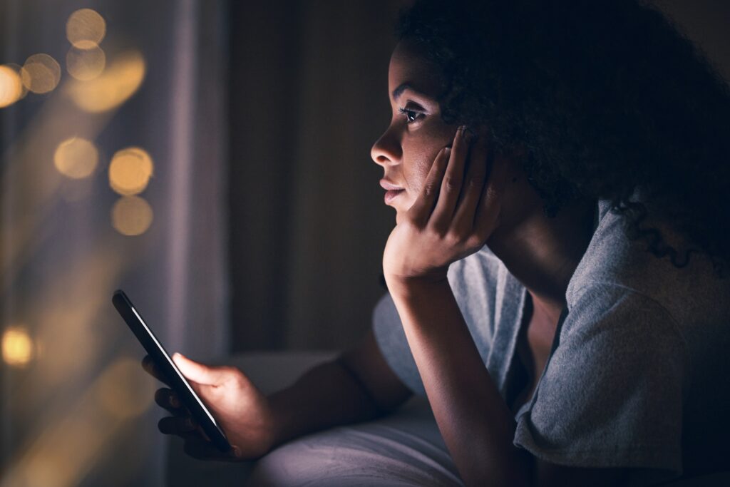 Thinking, night and phone with woman in bedroom for social media app, insomnia and networking. Comm
