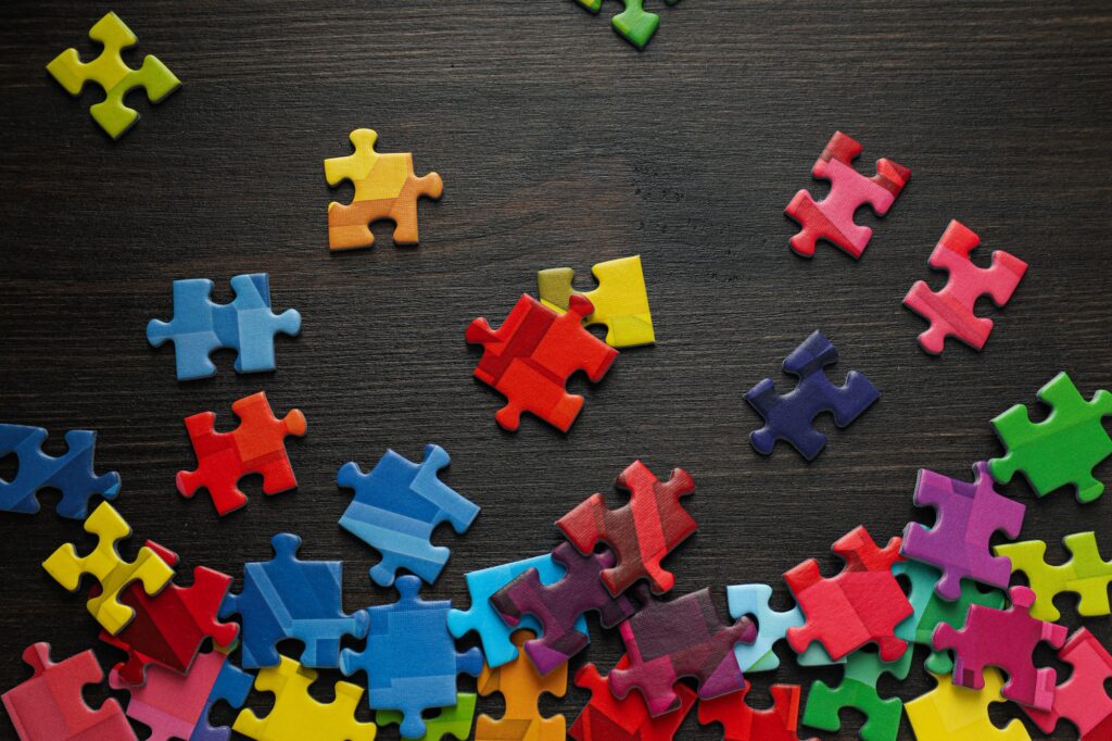 Multicolored puzzle pieces on a black background. World autism day concept