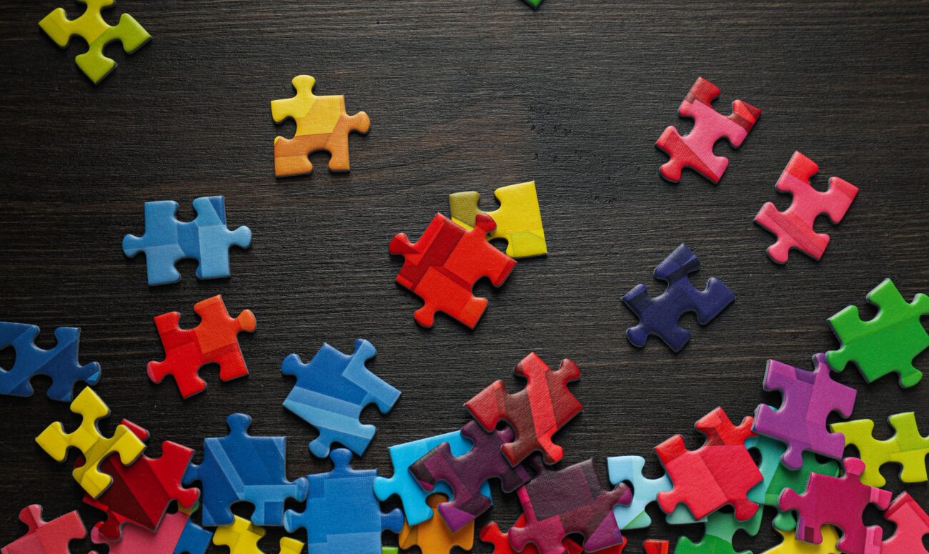 Multicolored puzzle pieces on a black background. World autism day concept