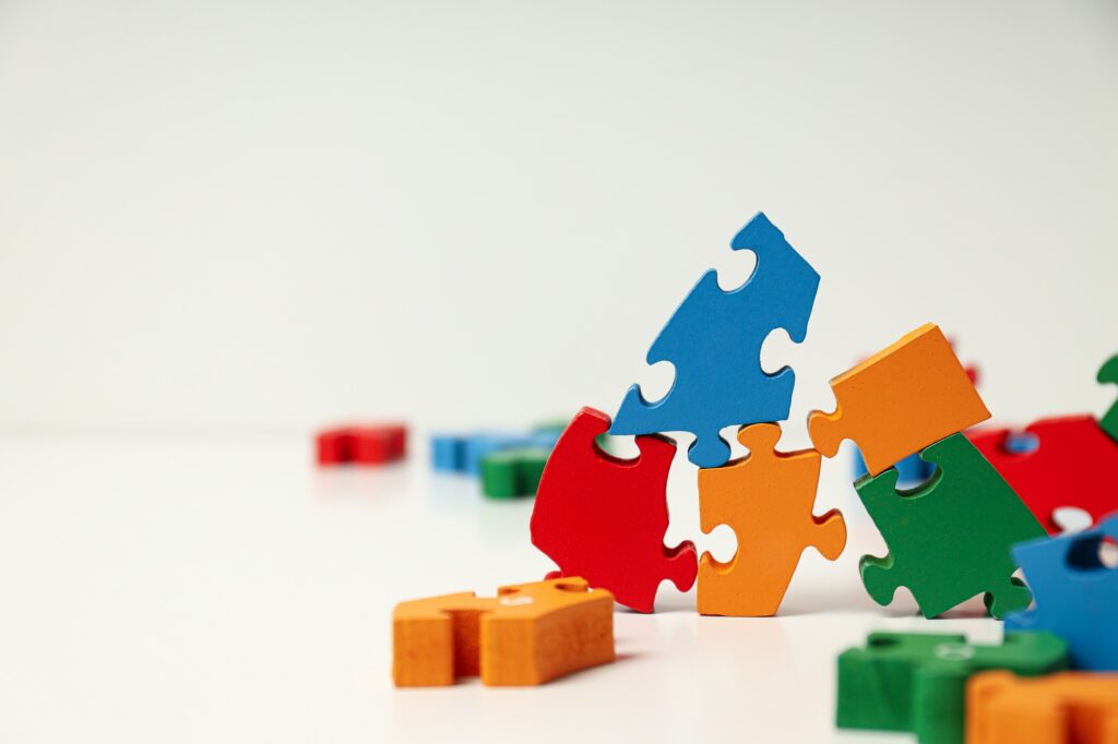 Multicolored puzzle pieces on a white background, place for text. World autism day concept
