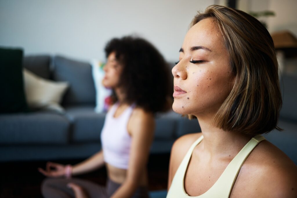 Women, fitness friends and meditation with mindfulness, wellness and peace of mind with breathing a