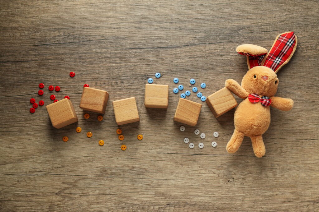 Wooden cubes with multi-colored buttons on a wooden background. World autism day concept